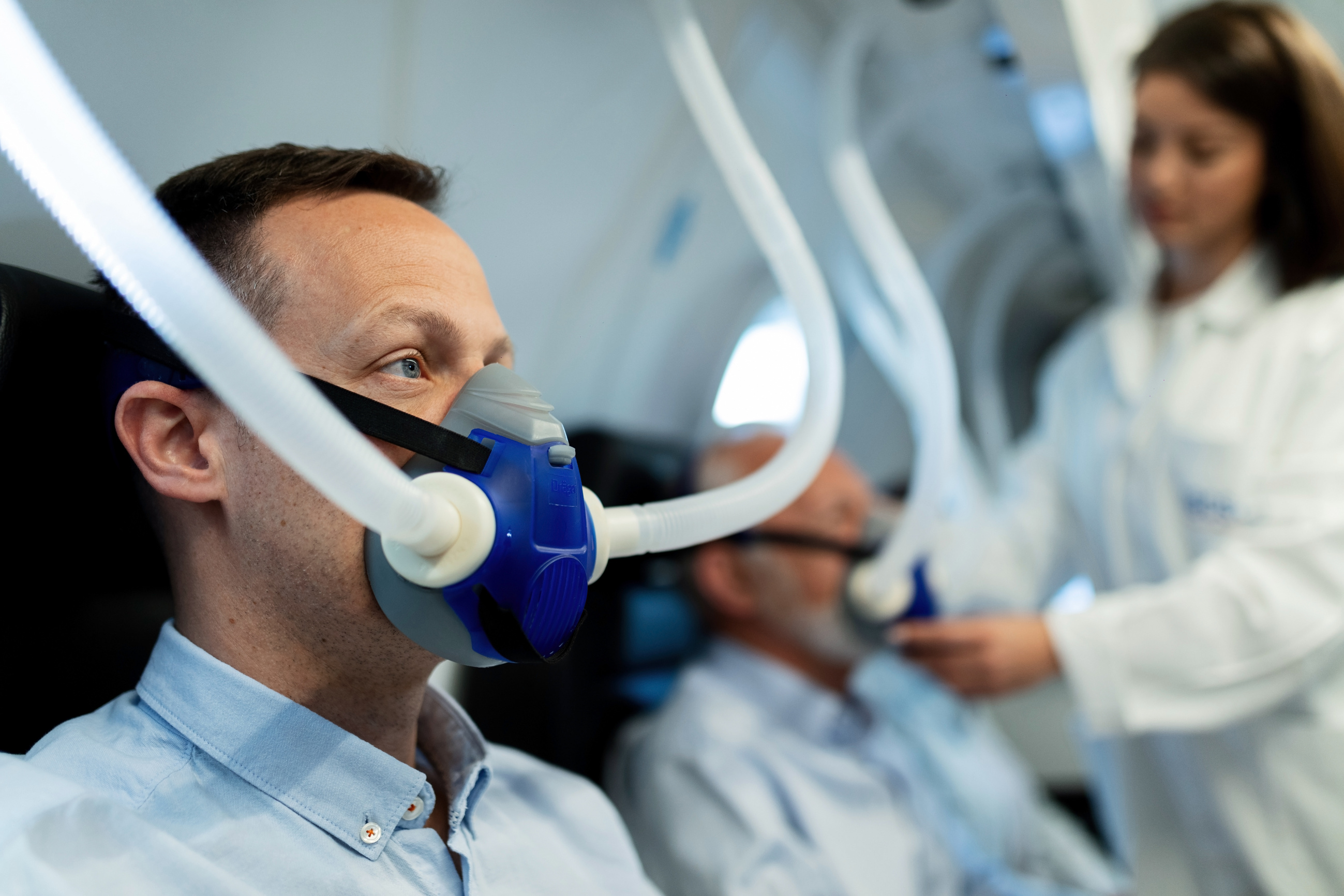 Male patient receiving oxygen therapy in hyperbaric chamber.